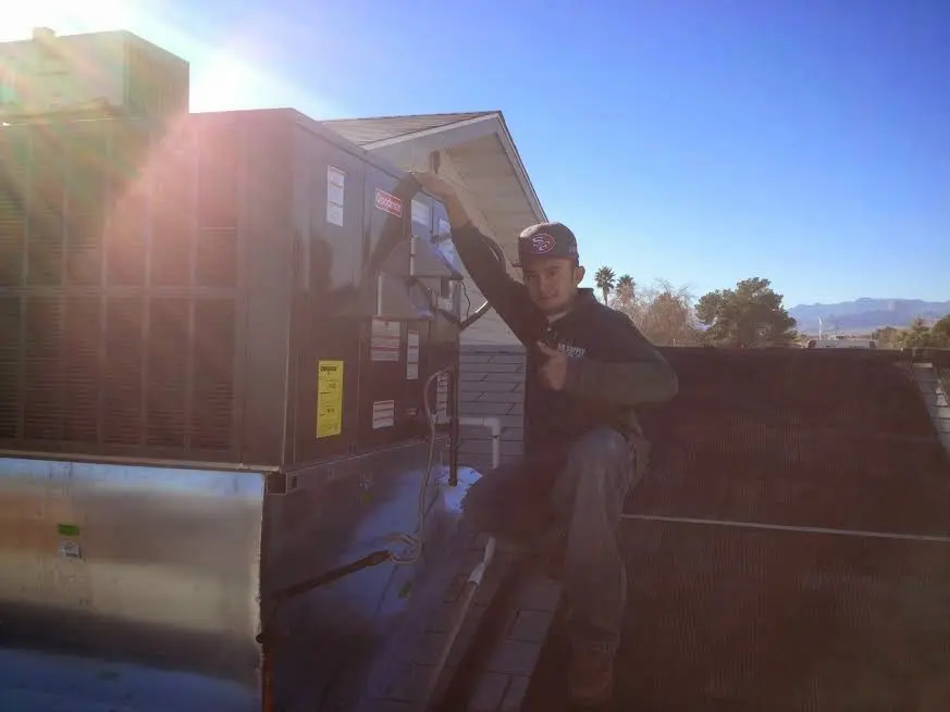 HVAC technician performing HVAC Inspection on a rooftop unit in Orion
